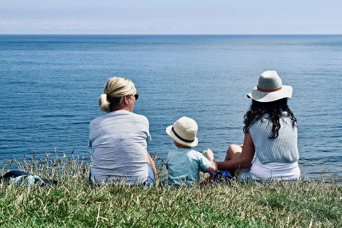 Family sitting on grass near the Sea