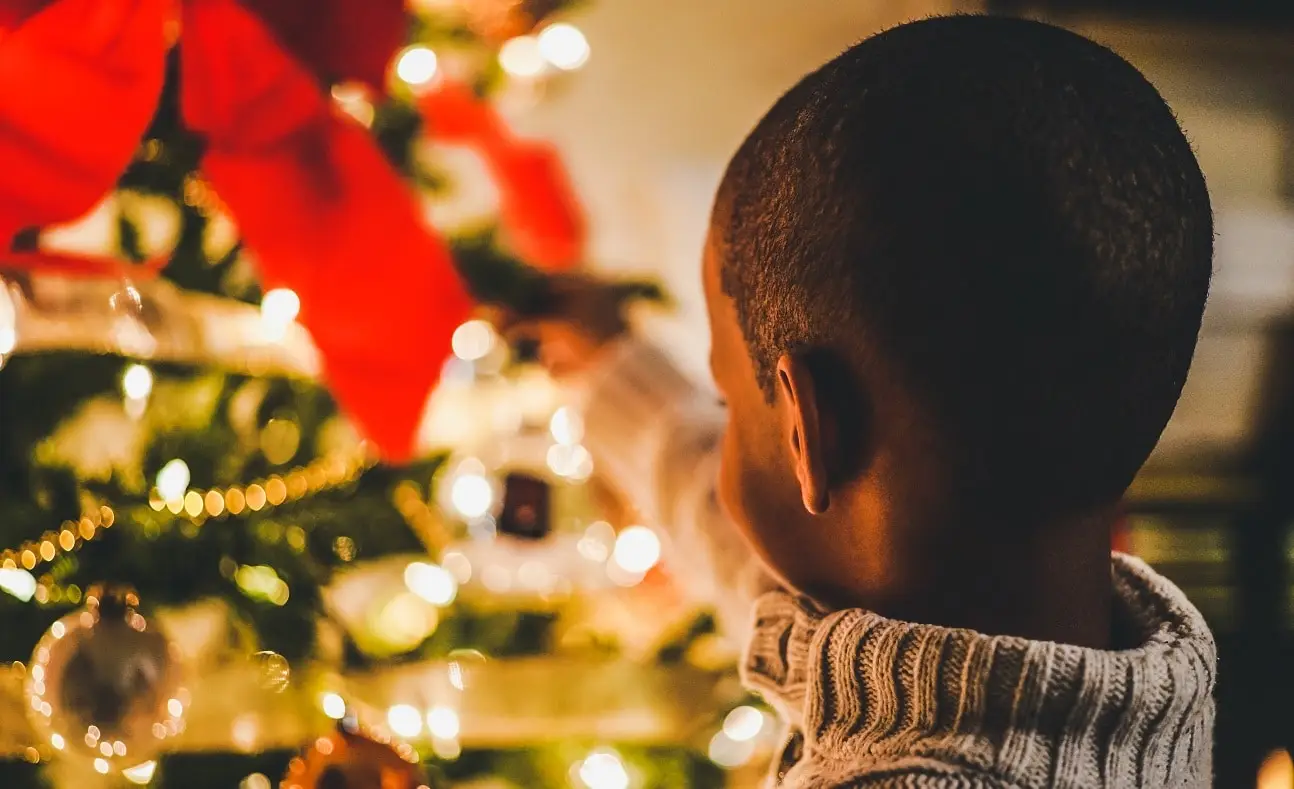 Child putting decorations on a Christmas Tree